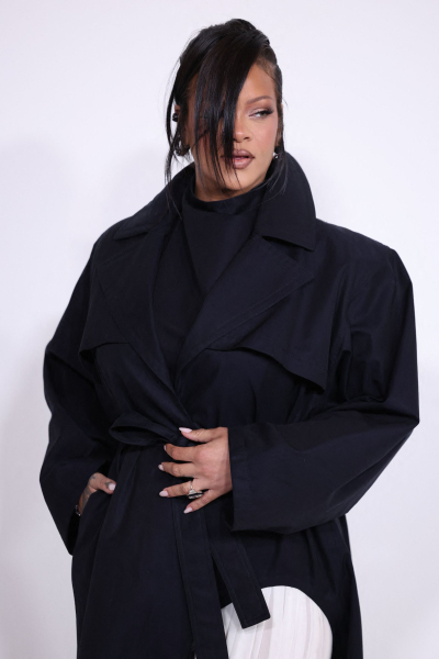 Rihanna attends the CFDA Awards in a turtleneck jacket white pants and a loose updo with side bangs.